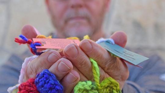 PHOTO BY LAURIE ANDERSON David James holds a handful of hearts crocheted for the Peyton Heart Project.