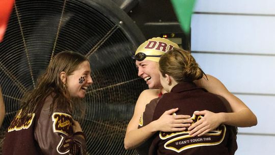 PHOTO BY JEFF MAY Laurel Hoskovec (senior) and Lexi Landrum (sophomore) celebrate with Abigail Owens (senior) after she swam a personal best time at UIL Regionals in the 100 Breaststroke.