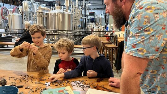 PHOTO BY LAURIE ANDERSON Matt Marchant, author of “A Shark Named Pickles,” identifies different objects, including shark teeth, for his young audience.