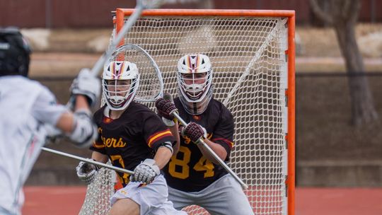 PHOTO BY BRAD AULT Jackson Kinley, #17 Sr Defenseman and John Ault, #84 Sr Goalie, defend against their opponent.