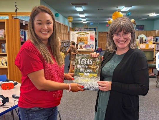 CONTRIBUTED PHOTO Jessica Rodriguez, Regent of the Sarah Pound Chapter NSDAR, presents the book to Children’s Librarian Olivia Ochoa.