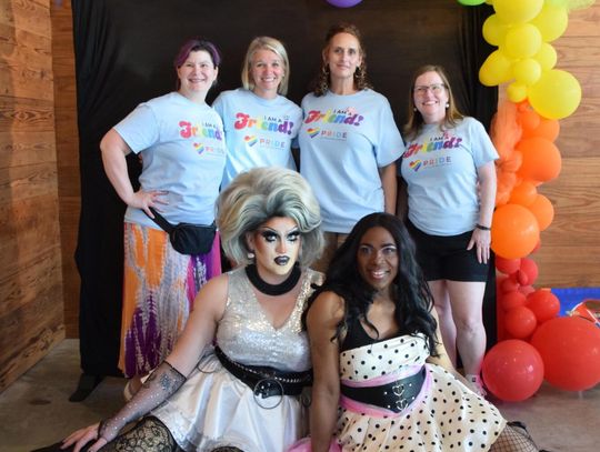 PHOTO BY LAURIE ANDERSON Pride of Dripping Springs board members Julie Balderramas, Jennifer Gamewell, Cynra McGuire and Nichole Newlan take a photo with Maxine LaQueene and Simone Jewel Riviera, who hosted Drag Queen Bingo.