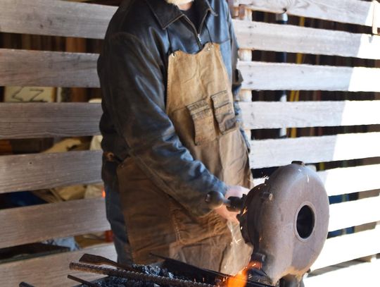 PHOTO BY LAURIE ANDERSON Matt the Blacksmith gets the fire hot in his forge.