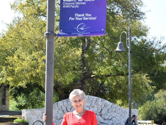 PHOTO BY LAURIE ANDERSON Mary Margaret Kyle Dement gets a first look at her dad’s banner, which hangs outside Hudson’s on Mercer.