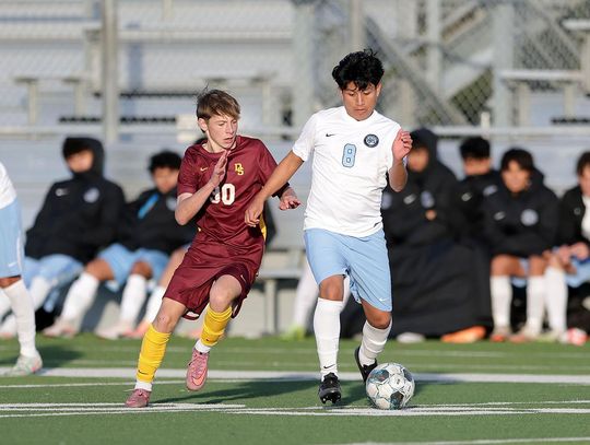 PHOTO BY VINCE CURLETTA Lane Hahnel (#30) tries to get past a Katy player in Saturday's tournament game. The final score was 4-2, with Dripping Springs taking the loss.