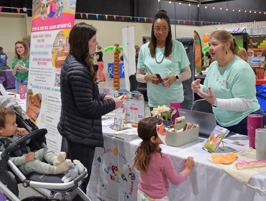 PHOTO BY LAURIE ANDERSON The representatives at Empower Kidz talk with a family about their offerings.