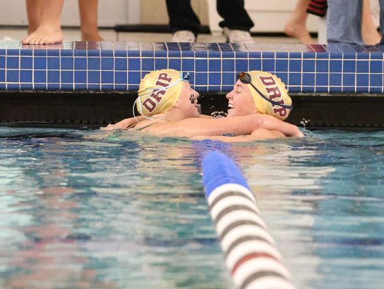 PHOTO BY JEFF MAY Junior Kylie May and senior Abigail Owens], teammates and close friends, celebrate after both swimming personal best times in the Girls 200 Yard Individual Medley.