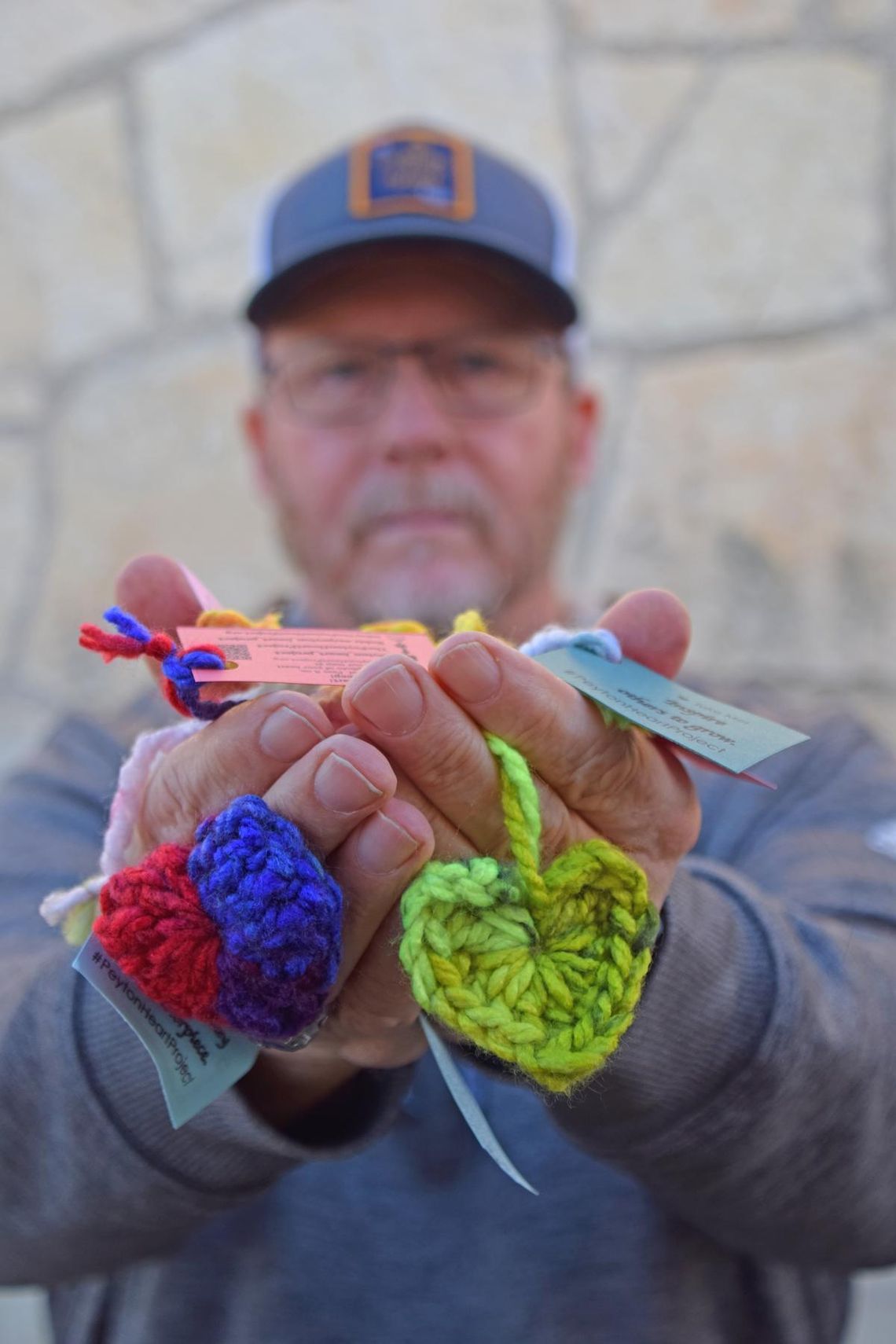 PHOTO BY LAURIE ANDERSON David James holds a handful of hearts crocheted for the Peyton Heart Project.