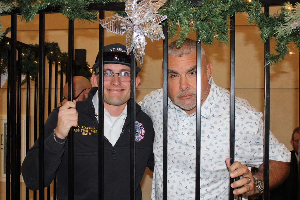 Wimberley Fire and Rescue Chief Chris Robbins behind bars with Hays County Sheriff Anthony Hipolito. Photo courtesy of Hays County Sheriff’s Office