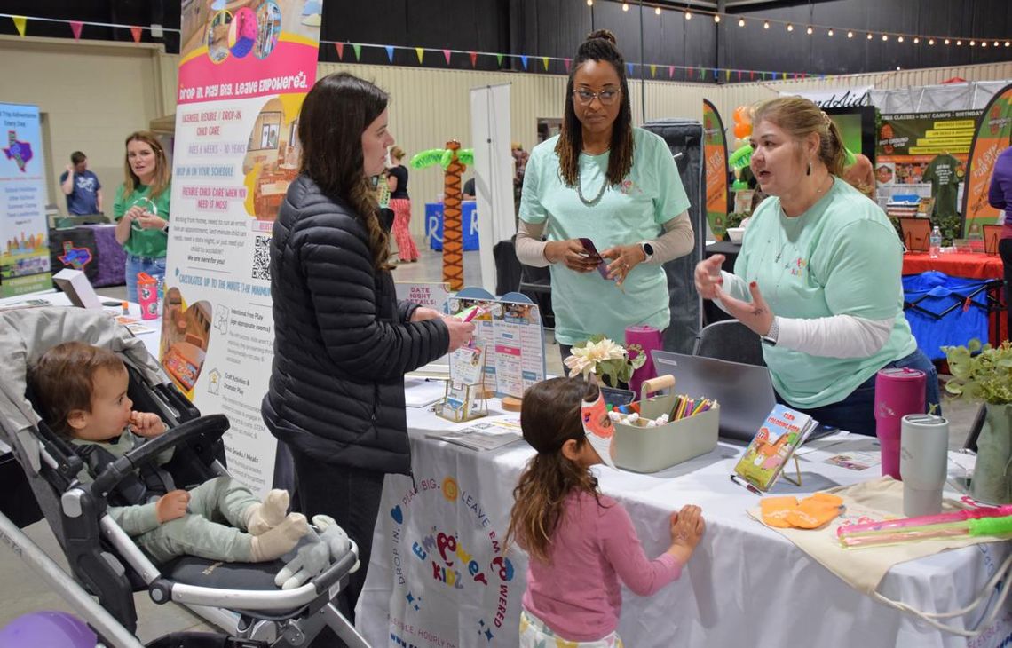 Summer Camp Fair brings families, providers together PHOTO BY LAURIE ANDERSON The representatives at Empower Kidz talk with a family about their offerings.