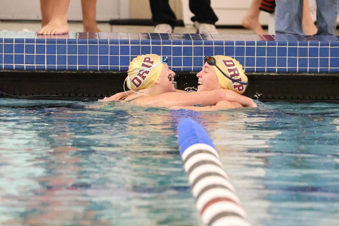 PHOTO BY JEFF MAY Junior Kylie May and senior Abigail Owens], teammates and close friends, celebrate after both swimming personal best times in the Girls 200 Yard Individual Medley.