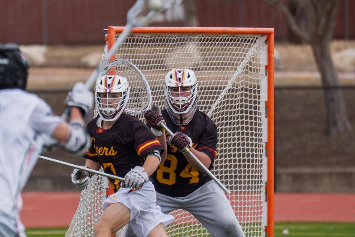 Tigers Lacrosse riding midseason momentum PHOTO BY BRAD AULT Jackson Kinley, #17 Sr Defenseman and John Ault, #84 Sr Goalie, defend against their opponent.