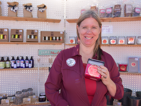 Monica Swenson, owner of Triple “S” Feeds, holds up a Circle E Candle from Fredericksburg, as a Christmas stocking stuffer idea. “We are locally owned, and we support local businesses,” she said.