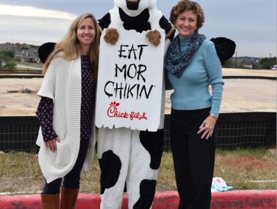 DSHS ROTC Club Sponsor Lauren Milner and DSISD Board Trustee Dr. Mary Jane Hetrick pose with the famous Chick-fil-A Cow.