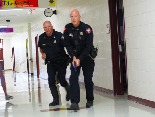 Pct. 4 Deputies Chick Williams and Jimmy Zuehlke enter a hallway looking for the suspect at the beginning of the exercise.