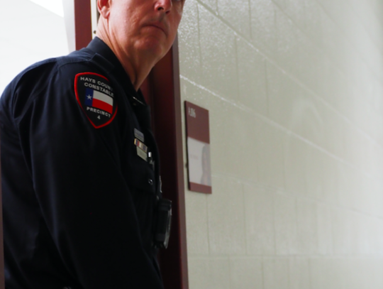 Pct. 4 Deputy Jimmy Zuehlke awaits North Hays Fire/Rescue and EMS by a secured room.