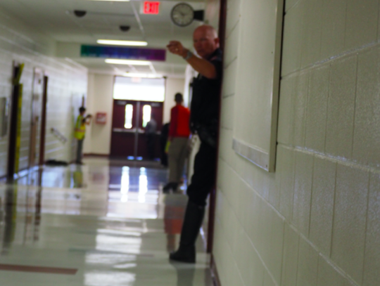 Pct. 4 Deputy Chick Williams signals the hallway is secure and its safe to bring in North Hays Fire/Rescue and EMS.