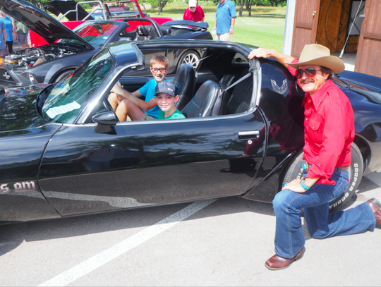 JB Lamb, as “The Bandid,” invited two young fans— Max Humel and Nick Schliemann—“to take seat” inside the classic 1979 Trans Am.