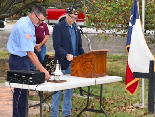 North Hays Firefighter Mark Treadway rings “four fives bells” to honor the fallen firefighters of 9/11. American Legion Commander Ben Adair stands at the podium.