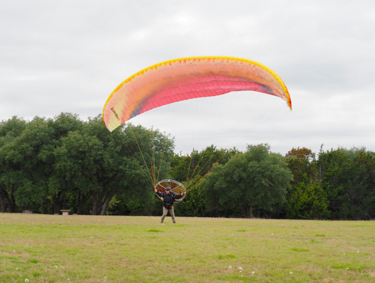 He cautiously walks forward, premitting the Paraglider to begin lifting him off the ground.