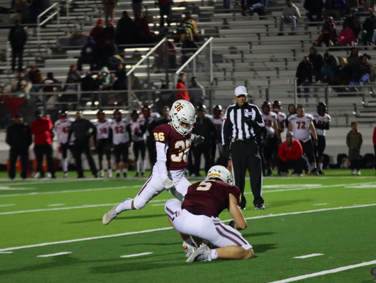 QB, No. 5, Zachary TjelmelandK holds the ball for No. 36, Desi De La Cruz