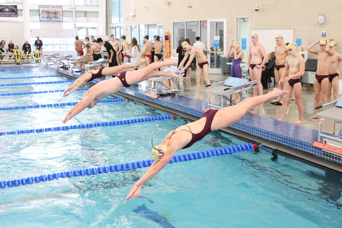 The Dripping Springs High School swim team takes a series of warmup dives bef...