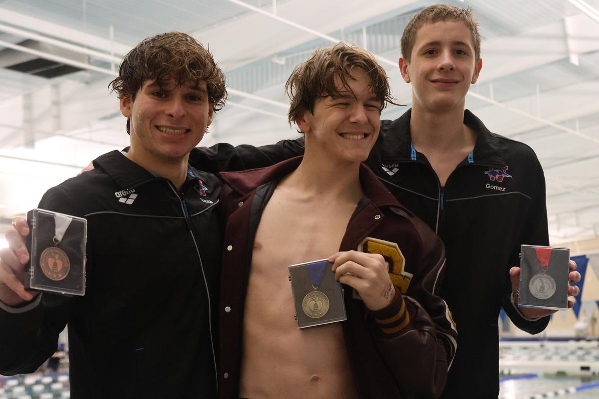 Senior Zach Collins (center) takes the podium for his first place win in the...