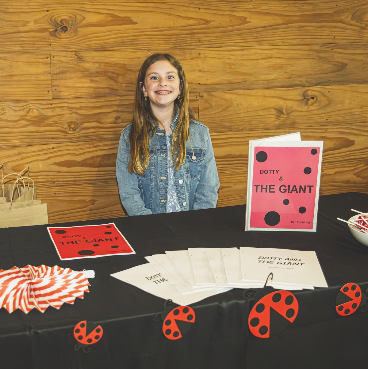 PHOTO BY JEREMY RASHAD BROWN Harper Sigur works her booth at the fair, with c...