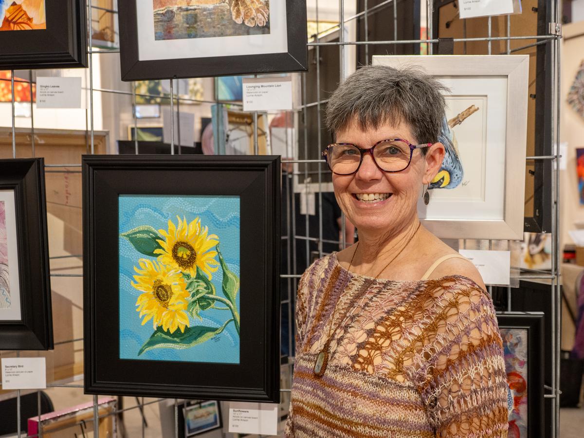 PHOTO BY DAVE WILSON Artist Lorrie Anson stands by some of her art on display...