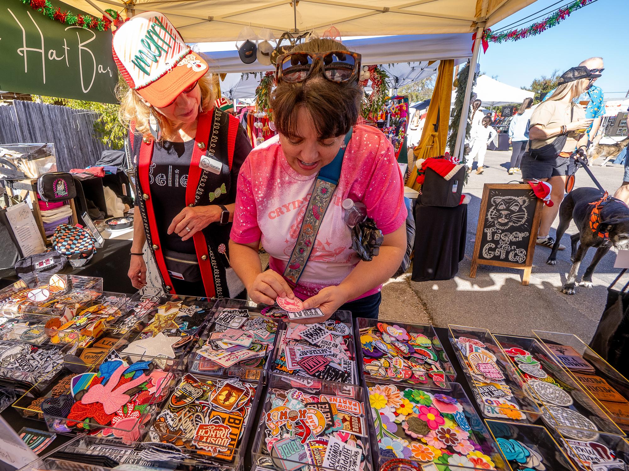 PHOTO BY DAVE WILSON Shoppers check out the merchandise at one of the vendor...