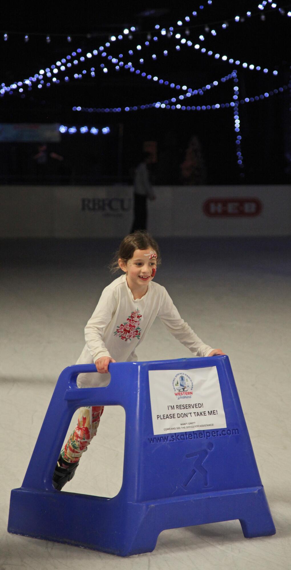 PHOTO BY LAURIE ANDERSON The skate helper gives a young skater some extra con...