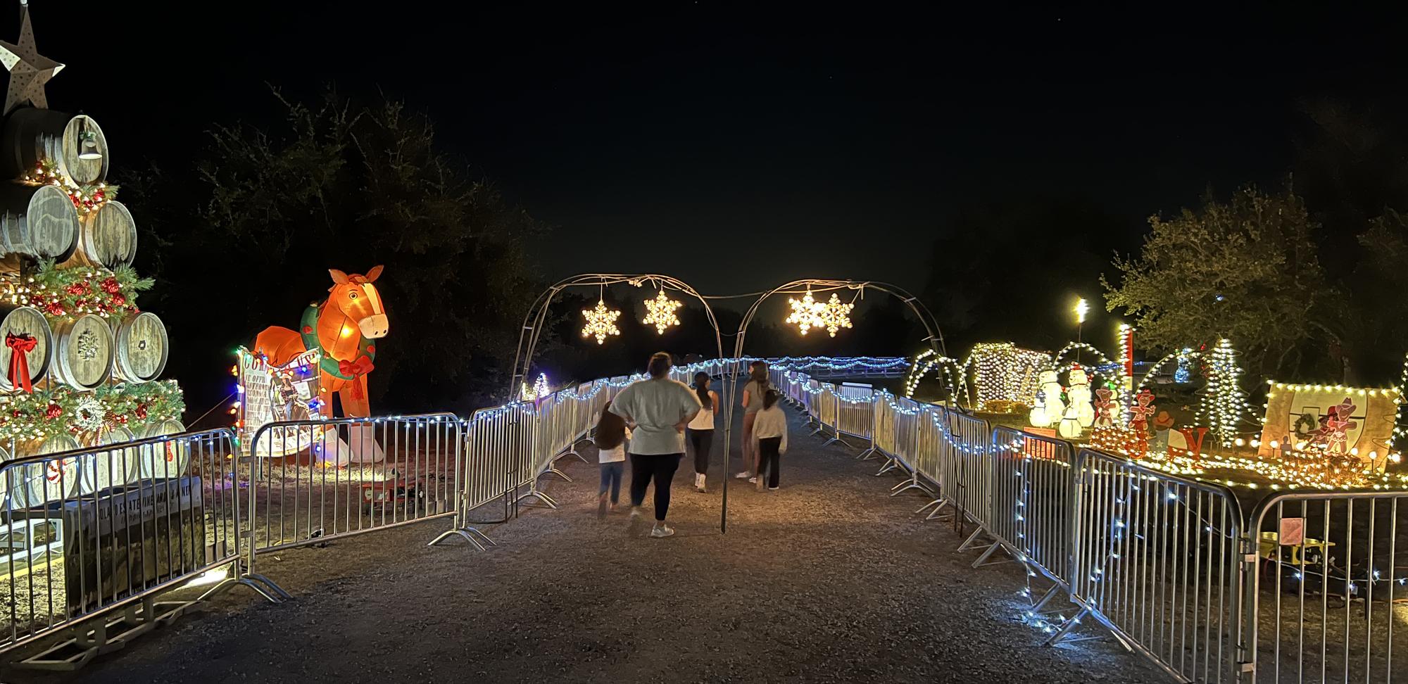 PHOTO BY LAURIE ANDERSON A family group enjoys the light displays along the t...